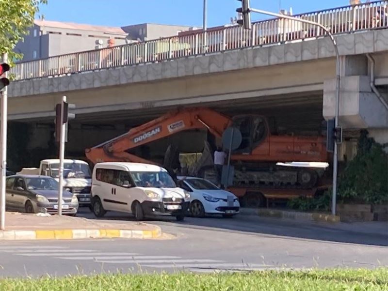Tırın dorsesinde taşınan iş makinesi köprülü kavşakta üst geçide sıkıştı
