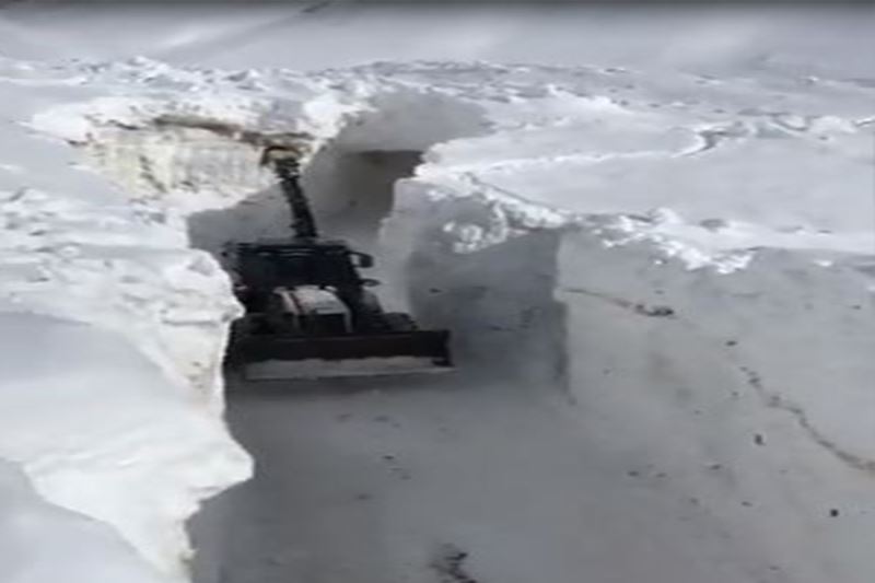 Kar kalınlığının iş makinelerinin boyunu geçtiği yolda zorlu çalışma